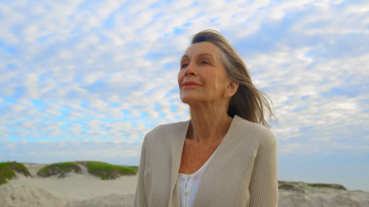 Active senior Caucasian woman standing on the beach 4k