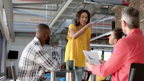 mujer de negocios afroamericana discutiendo con un equipo de colegas en la oficina