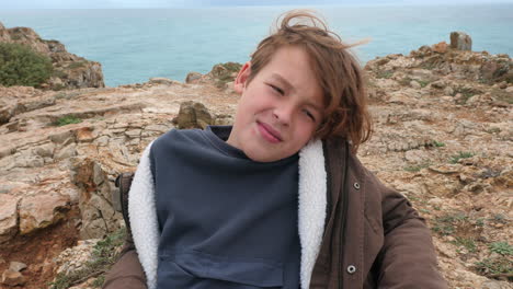 Cheerful-boy-on-the-headland-rocks