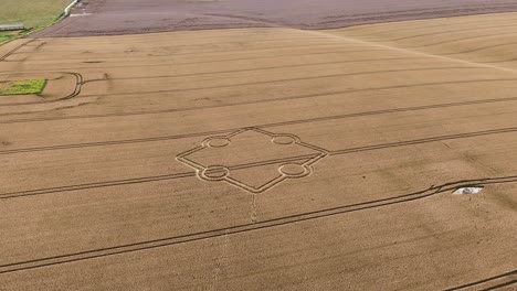 Stone-henge-square-crop-circle-formation-aerial-view-approaching-golden-rural-farmland-field-design