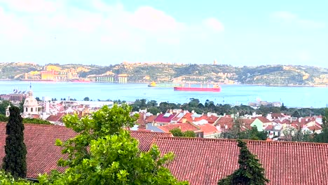 Ciudad-De-Almada-En-El-Río-Tajo-Con-Barcos-Pasando,-Vista-De-Lisboa