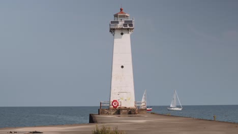 Dos-Barcos-Pasando-Por-El-Pequeño-Faro-Toma-De-Los-Faros-En-Sodus-Point-Lugar-De-Vacaciones-De-Nueva-York-En-La-Punta-De-La-Tierra-A-Orillas-Del-Lago-Ontario