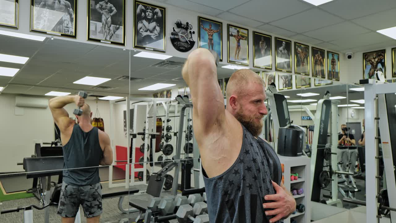 Active bodybuilder young man lifting heavy weights