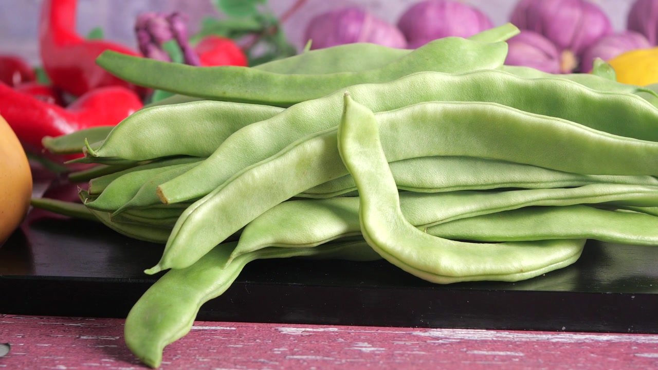Fagiolini freschi su un tagliere con altre verdure