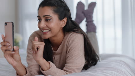 Hermosa-Mujer-Teniendo-Video-Chat-Usando-Un-Teléfono-Inteligente-Charlando-Con-Un-Amigo-Disfrutando-De-Una-Conversación-Acostada-En-La-Cama-Relajándose-En-Casa