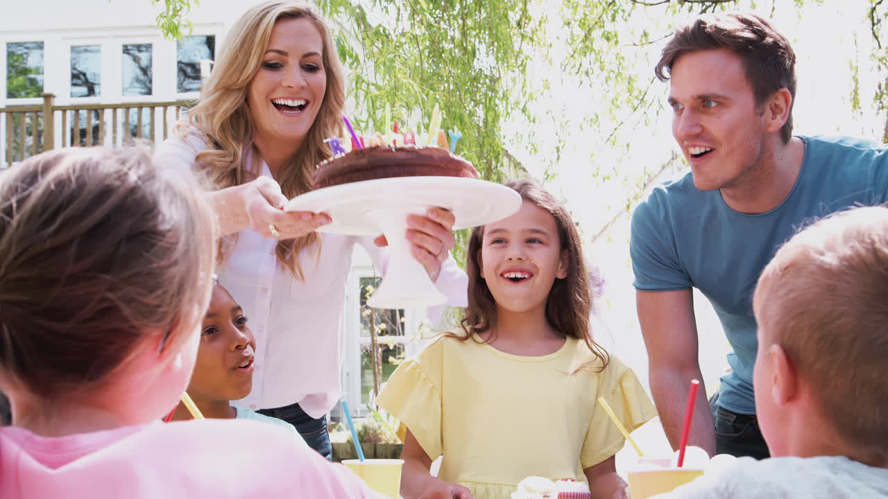 딸 과 함께 부모 는 집 에서 정원 에서 파티 를 열고 있는 친구 들 과 함께 생일을 축하 하고 있다