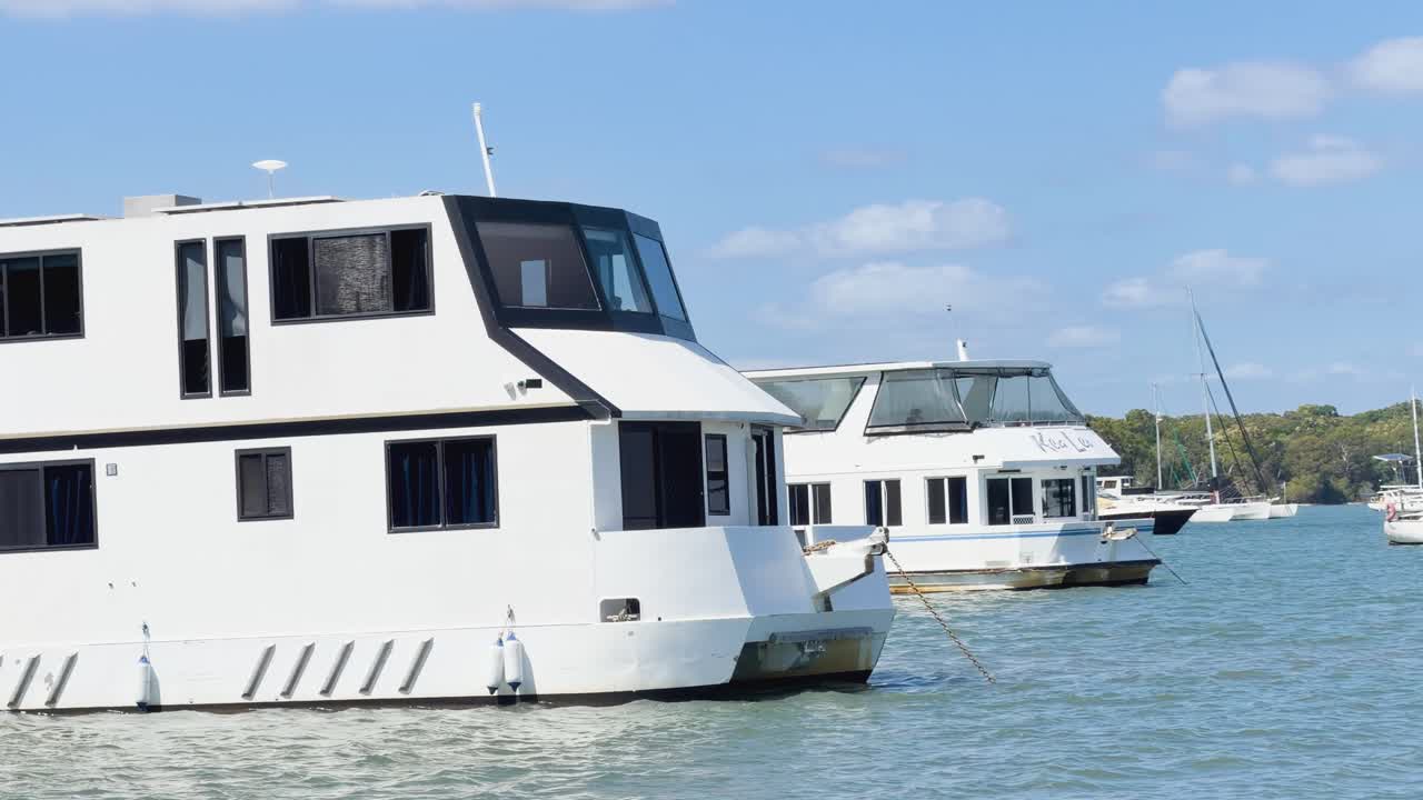 Una grande casa galleggiante bianca浮かぶsu acqua blu calma sotto un cielo azzurro e soleggiato