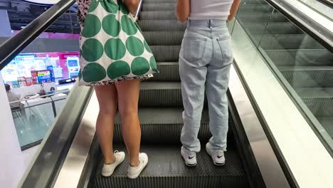 two people ascending an escalator together