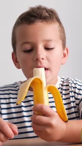 young boy eating a banana