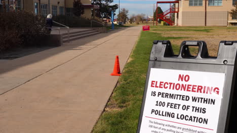 No-Electioneering-is-Permitted-Within-100-Feet-of-this-Polling-Location-Sign-with-old-woman-walking-in-Background