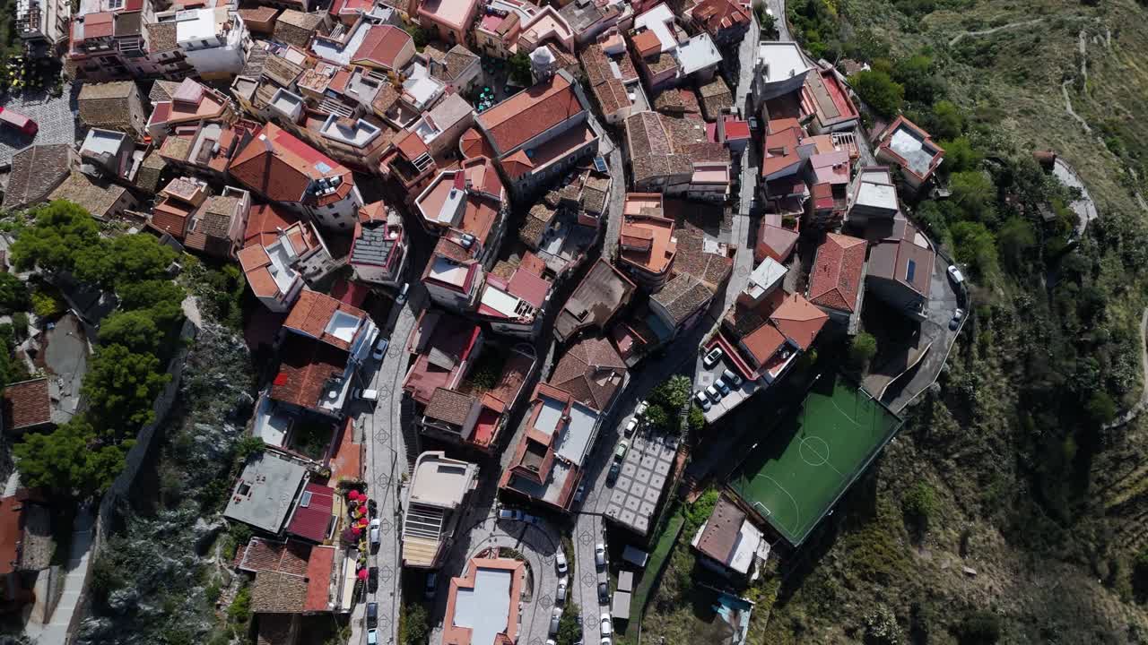 Vista aérea de drone de Castelmola, Sicília, com montanhas no plano de fundo, <1>filmagem</1> cinematográfica em <2>vídeos em 4K</2> <3>60FPS</3> mostrando a histórica vila na encosta, os telhados e a paisagem mediterrânea