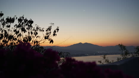 colorful sunset and moon above the tropical ocean and mountains in mexico