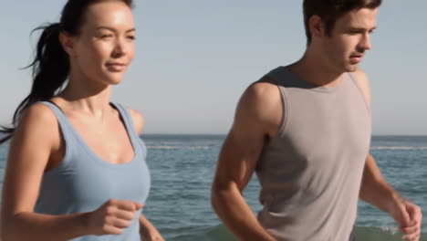 amigos atractivos corriendo en la playa.