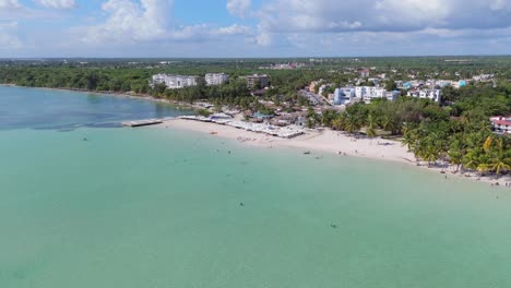 people swimming in ocean green water, boca chica beach in the caribbean, aerial