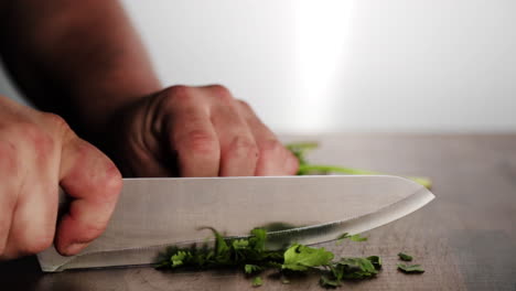 Chef-Profesional-Cortando-Perejil-En-Un-Tajo-De-Madera