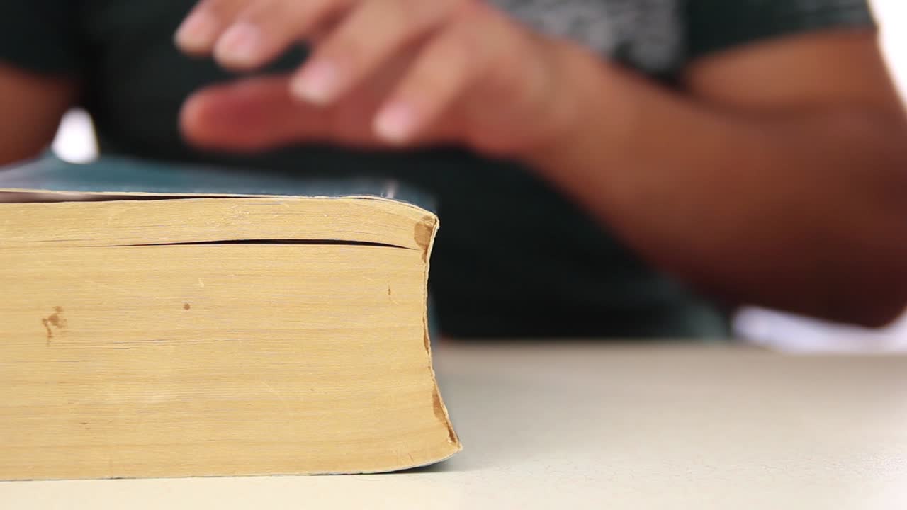 남성 학생 가까이서 책을 읽습니다.