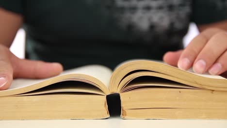 estudiante de sexo masculino leyendo un libro de cerca