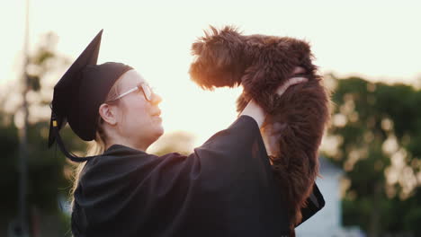 A-Woman-In-A-Graduate-Costume-Holds-A-Cute-Puppy-In-Her-Arms-College-Graduation-Gift