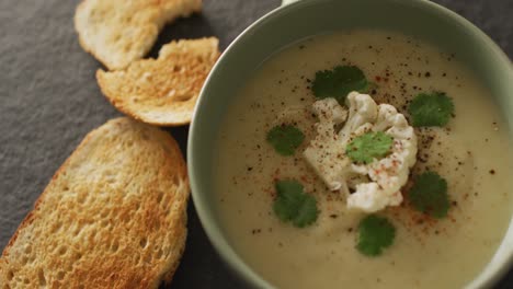 video of cauliflower soup and ingredients lying on grey surface