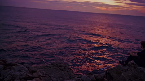 man contemplating sunset over the ocean