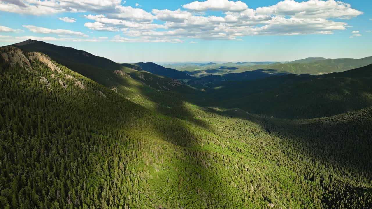 las sombras de las nubes y la luz del sol proyectan patrones sobre el bosque perenne de mount blue sky, colorado.