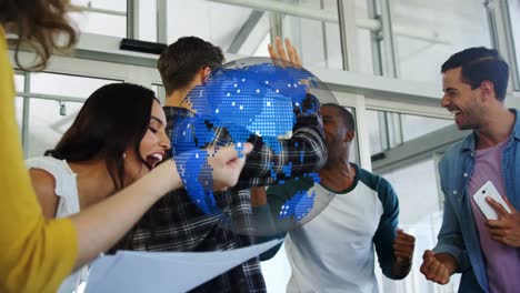 animation of rotating globe over happy diverse colleagues celebrating at casual office meeting