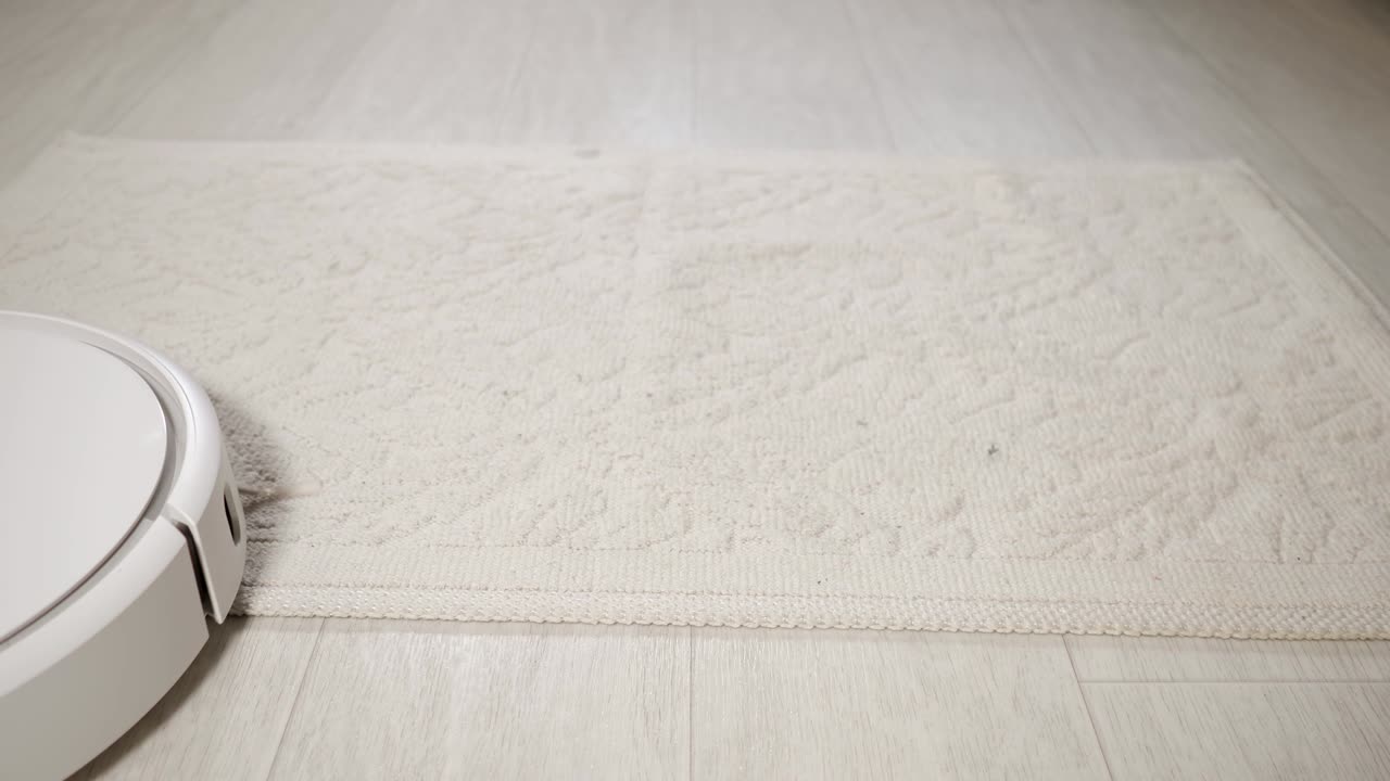 un robot aspirador limpia una pequeña alfombra