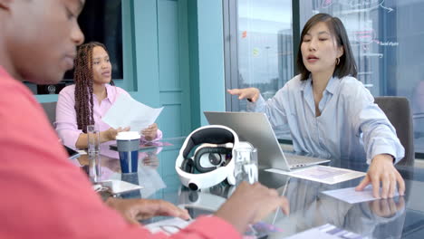 discussing project, diverse team collaborating with laptop and documents in office