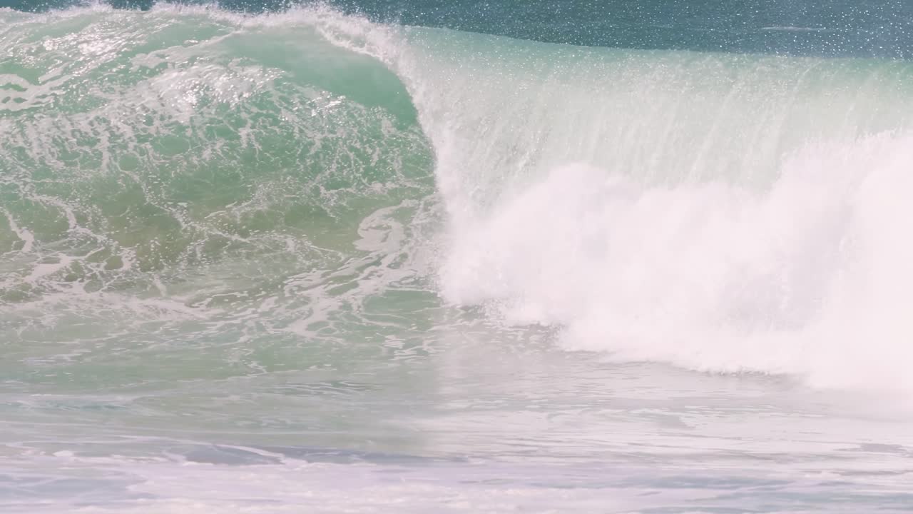 Close-up view of powerful ocean waves crashing and forming barrels with white foam and spray.