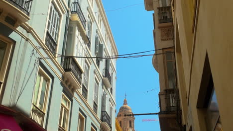 historic streets of málaga, spain, with traditional mediterranean buildings and balconies, leading to the city's iconic cathedral, captured under clear blue skies