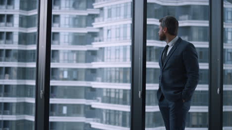 successful businessman looking out window