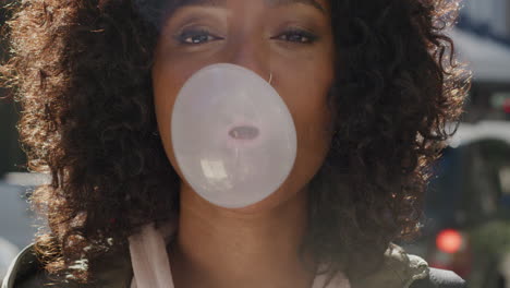 retrato de una feliz mujer afroamericana soplando chicle