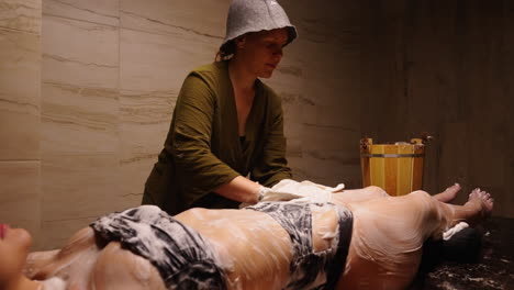 woman receiving a body scrub treatment at a spa