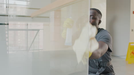 close up view of cleaning man cleaning crystal walls inside an office building