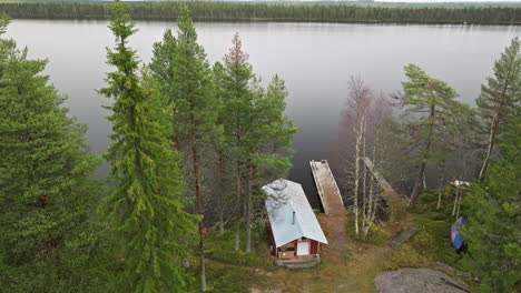 Levantándose-Sobre-Una-Cabaña-Roja-A-Orillas-De-Un-Lago-Tranquilo-En-El-Campo-De-Suecia