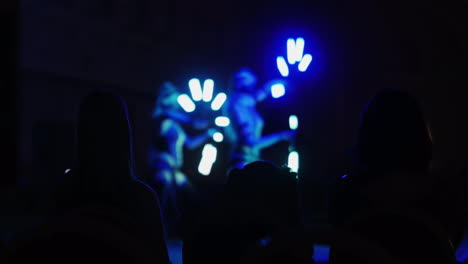 silhouettes of spectators watching a dance show with beautiful backlighting