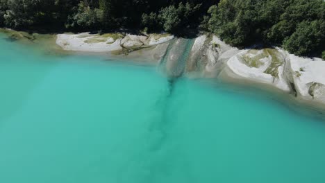 el agua dulce de las montañas entra en el lago glaciar verde