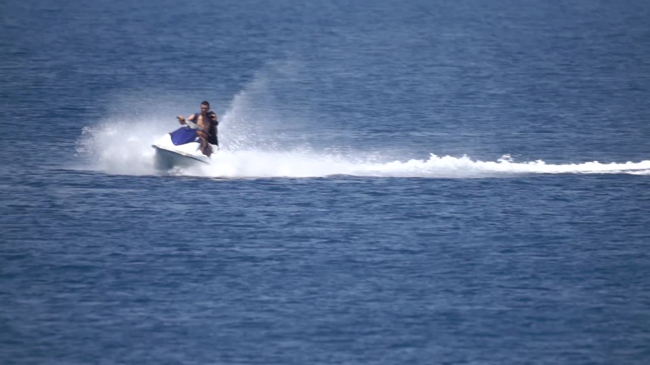 jetski de alta velocidad montando en el mar en una toma de acción a cámara lenta