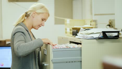 business woman takes a folder with documents from a drawer in retro style