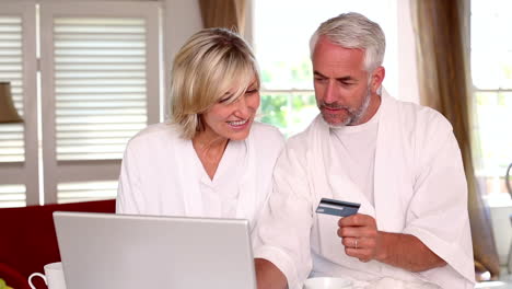 happy couple shopping online in bathrobes