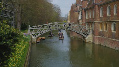 riverboats are pushed through calm waters under bridge by tour guide in england