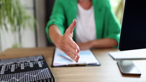 business handshake at office desk