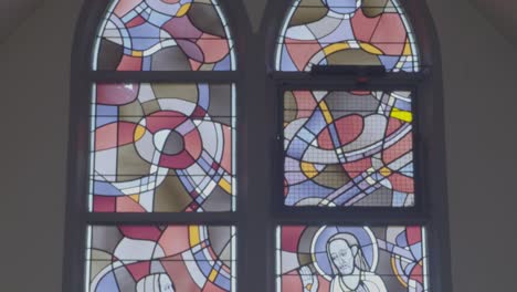 camera panning along colorful church window with christian images