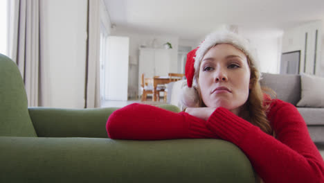 Mujer-Con-Sombrero-De-Papá-Noel-Tumbada-En-El-Sofá-De-Casa