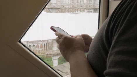 hombre asiático usando teléfono móvil mientras viaja en transporte público skytrain