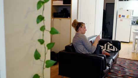 Woman-relaxing-on-sofa-and-reading-book