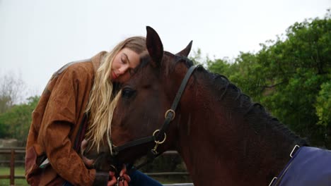 Woman-hugging-horse-on-wooden-fence-at-ranch-4k