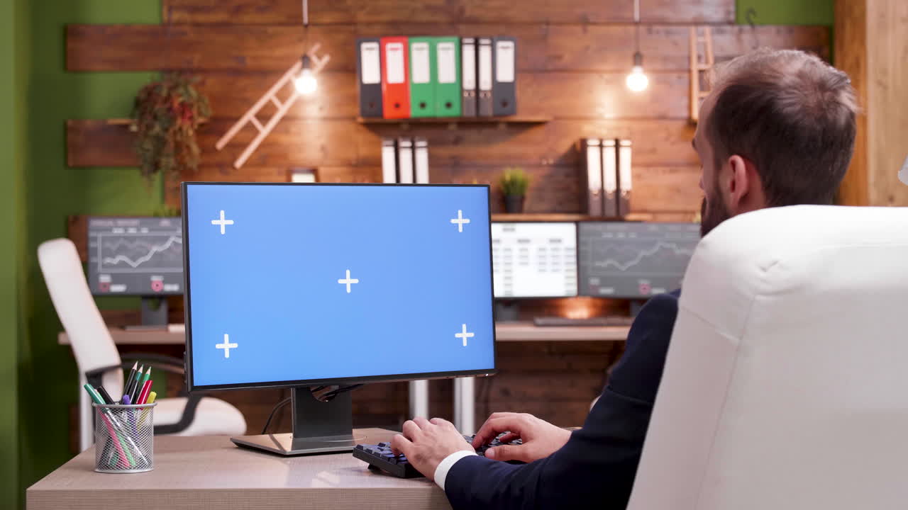 Businessman working at his desk with a blue screen computer