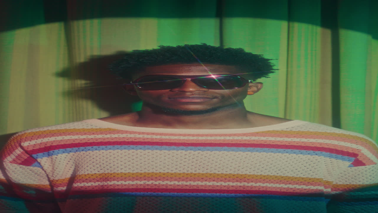 Portrait of Young Black Man in Striped Sweater and Retro Sunglasses