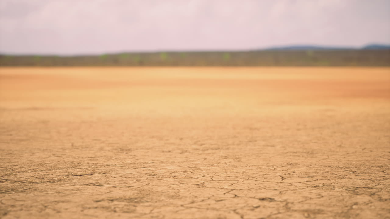Dry cracked earth under a cloudy sky in a remote landscape during daytime